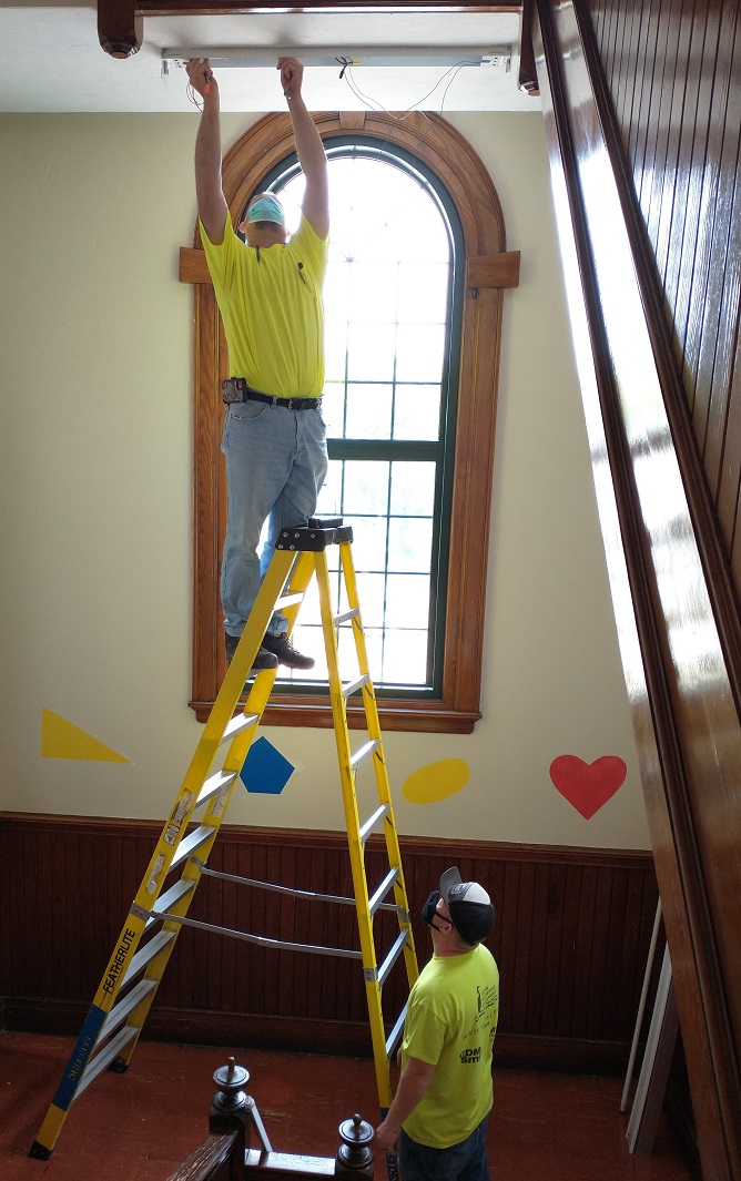 Local workers from Delsignore Electrical Contractors Inc., subcontracted by Honeywell, have spent 20 hours changing out Midland Elementary School’s 169 lights last week. Ethan McMahon, foreman, is being assisted by Scott Perkins, the apprentice.
